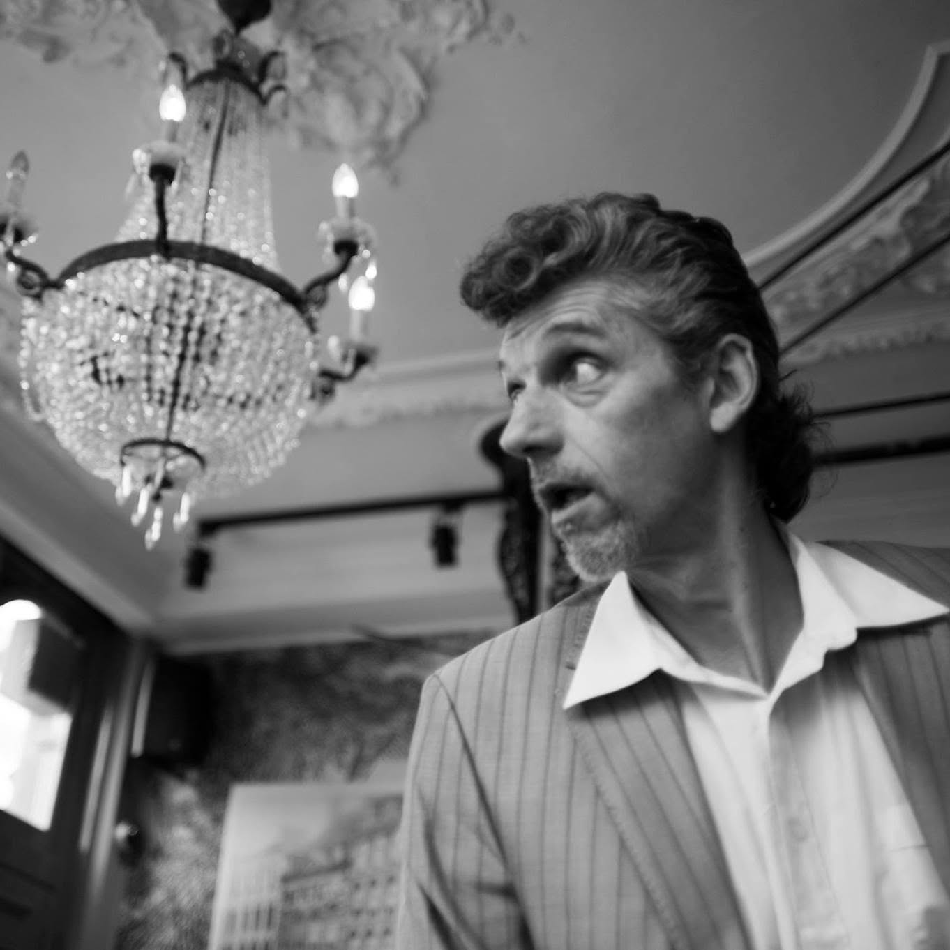 Fernand Bernadi in pak, onder een kristallen kroonluchter